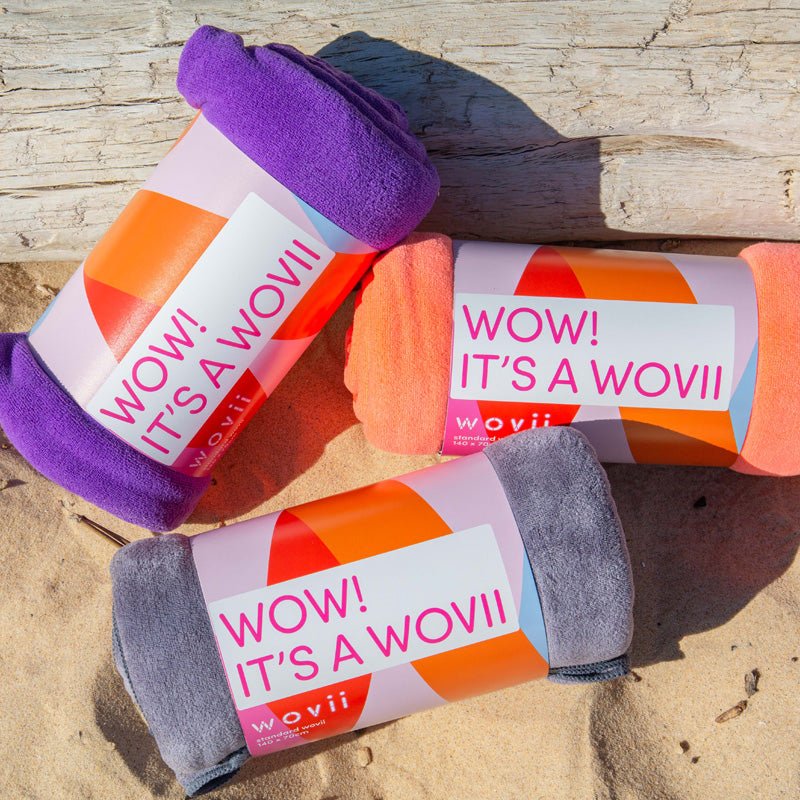 3 wovii sandfree microfibre towels in a collection on a beach