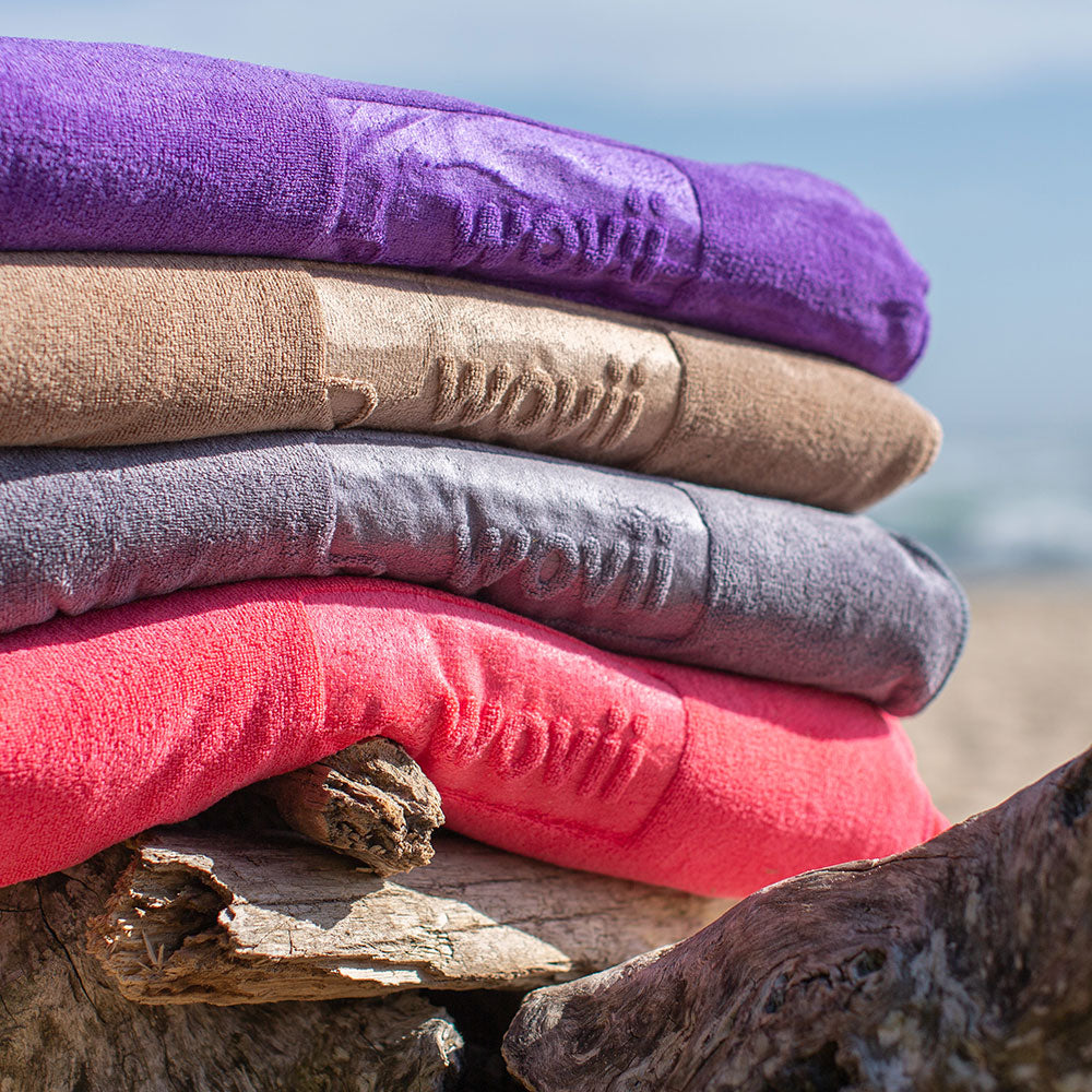 Sand free beach towels stacked 4 high in a natural surrounding 